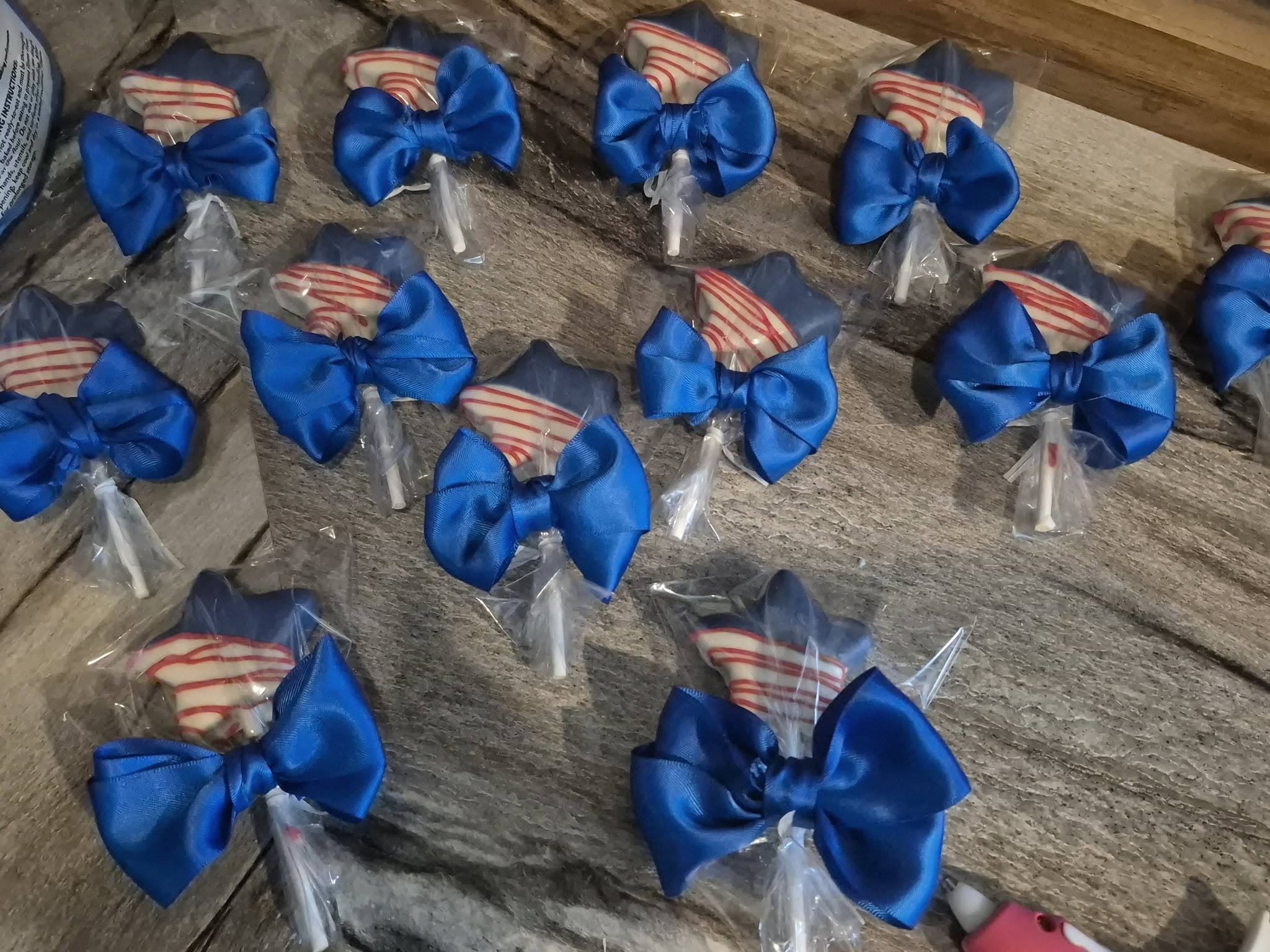 Cake pops with blue bows and striped candy toppers