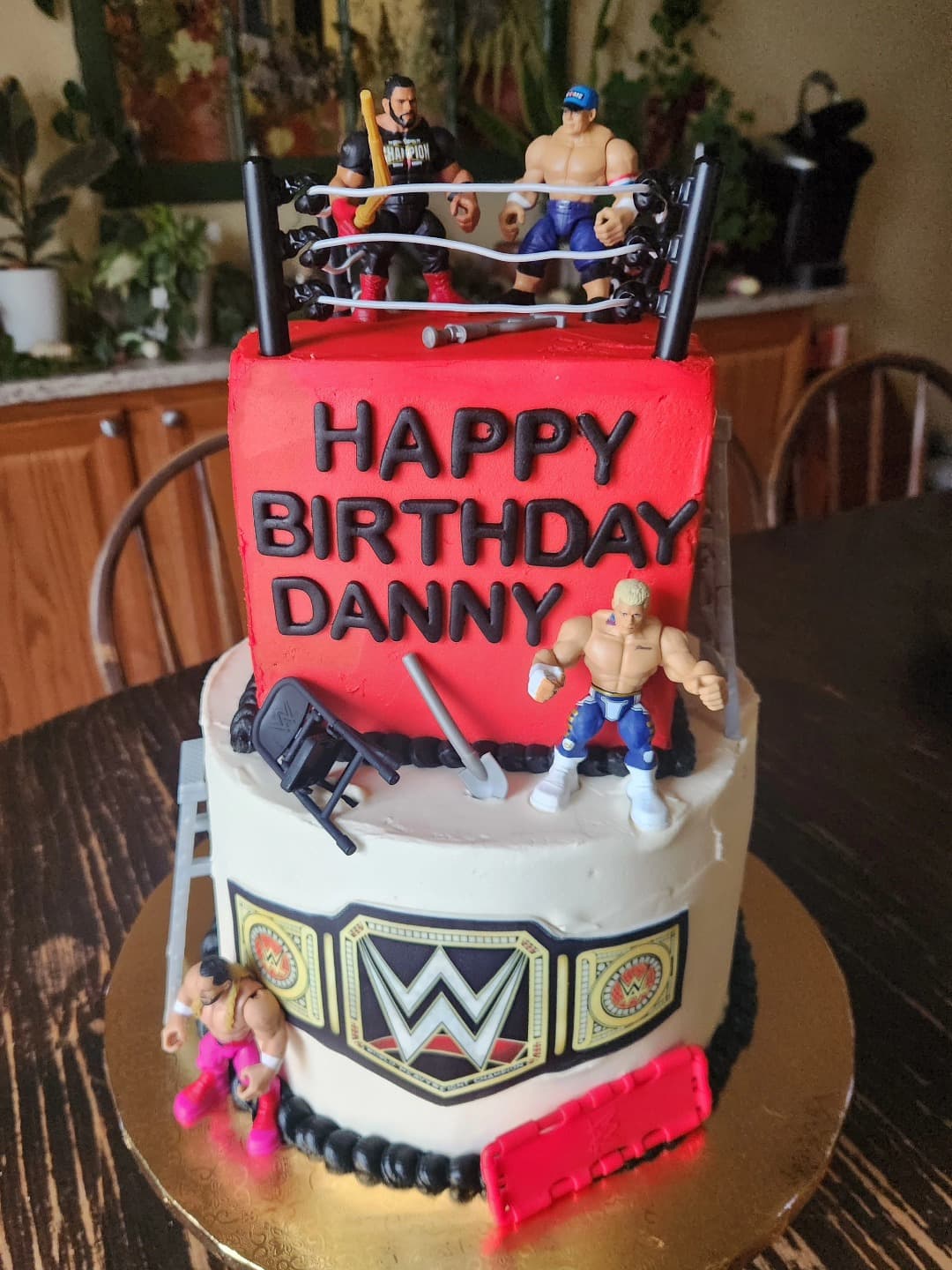 Multi-tiered custom cake with wrestling theme decorations