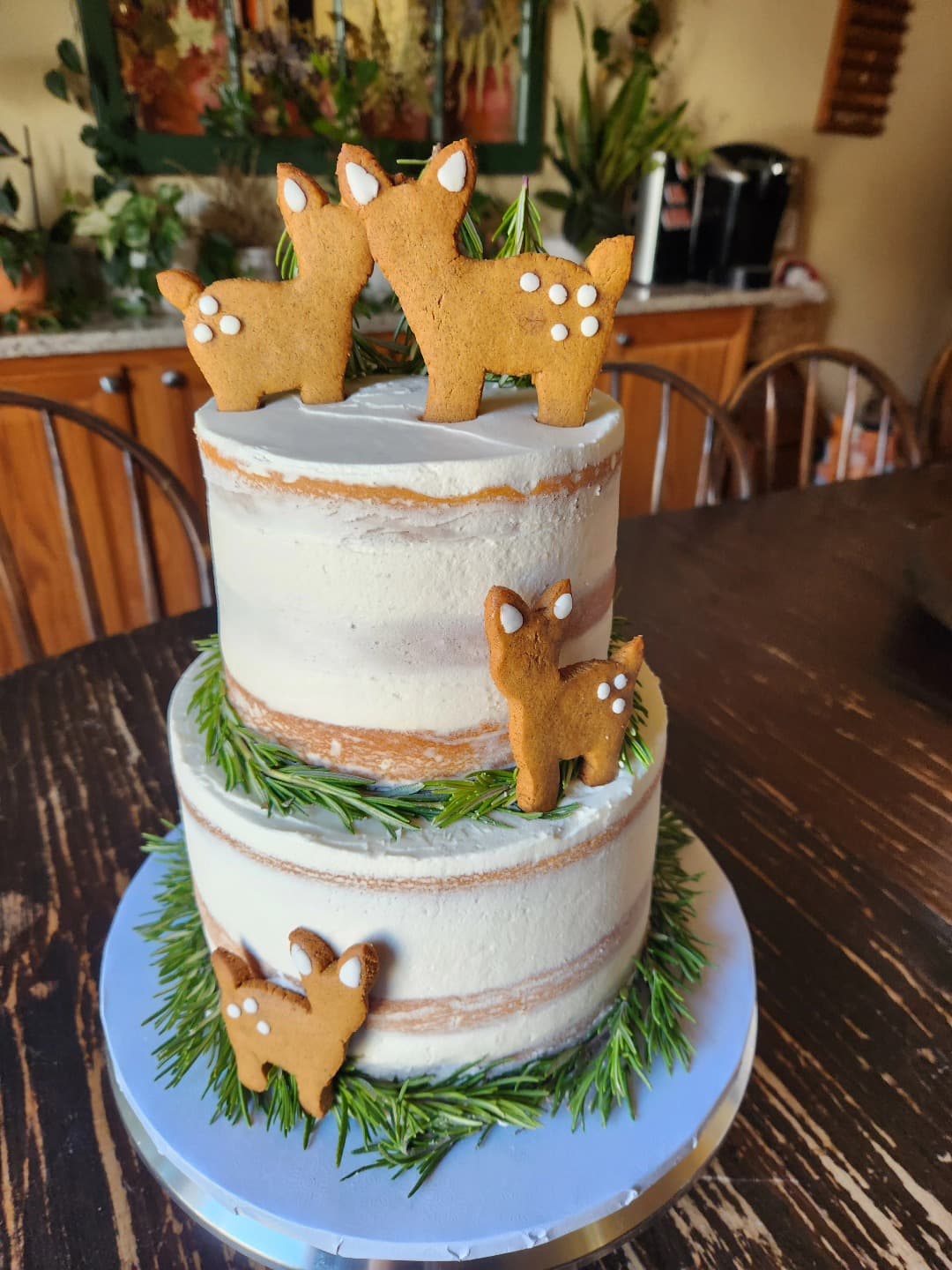 Tiered naked cake with gingerbread llama toppers and rosemary